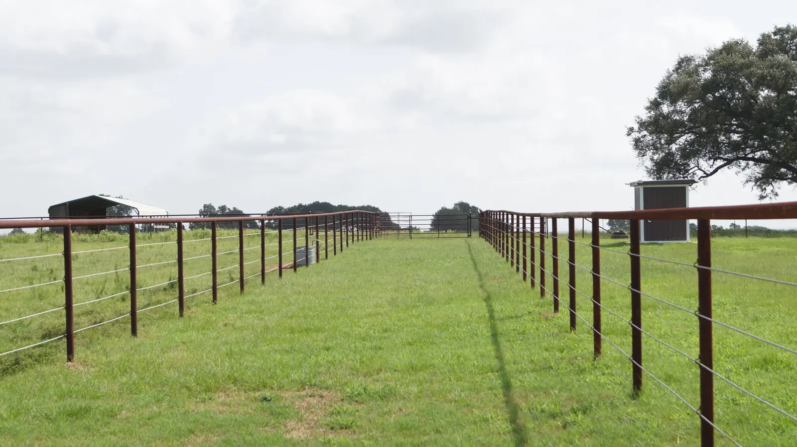 Pipe-fenced pastures leading toward the barn at Twin Oaks Ranch