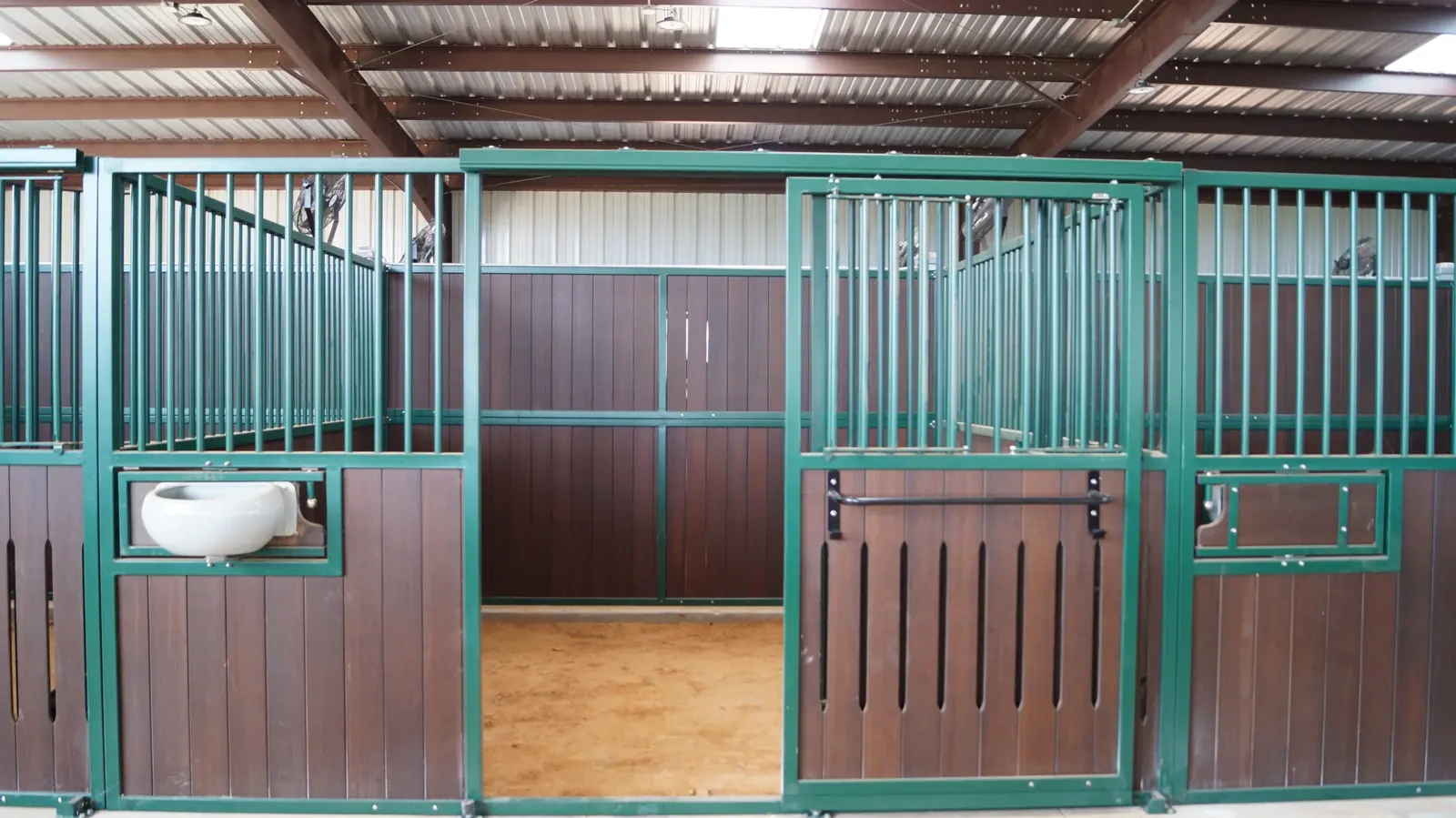 Row of 12 by 12 foot horse stalls inside the covered barn at Twin Oaks Ranch