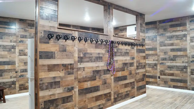 Bridle hooks and wood-plank walls in the tack room
